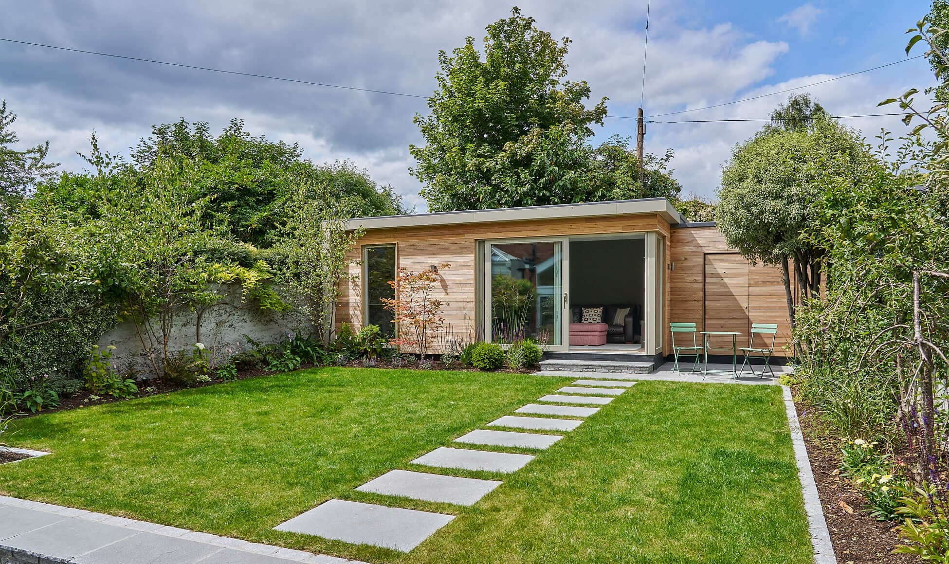 A timber-clad Shomera garden studio set in a mature garden