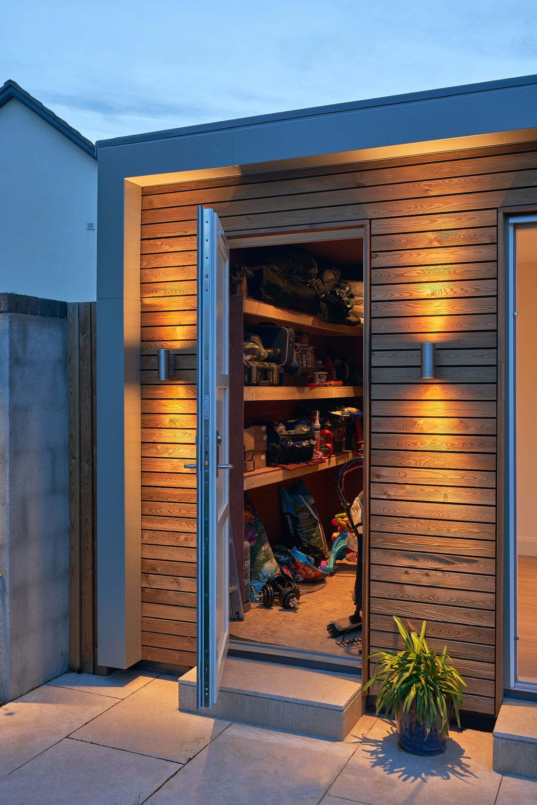 The open storage bay at dusk, fitted out with shelving for bikes and equipment
