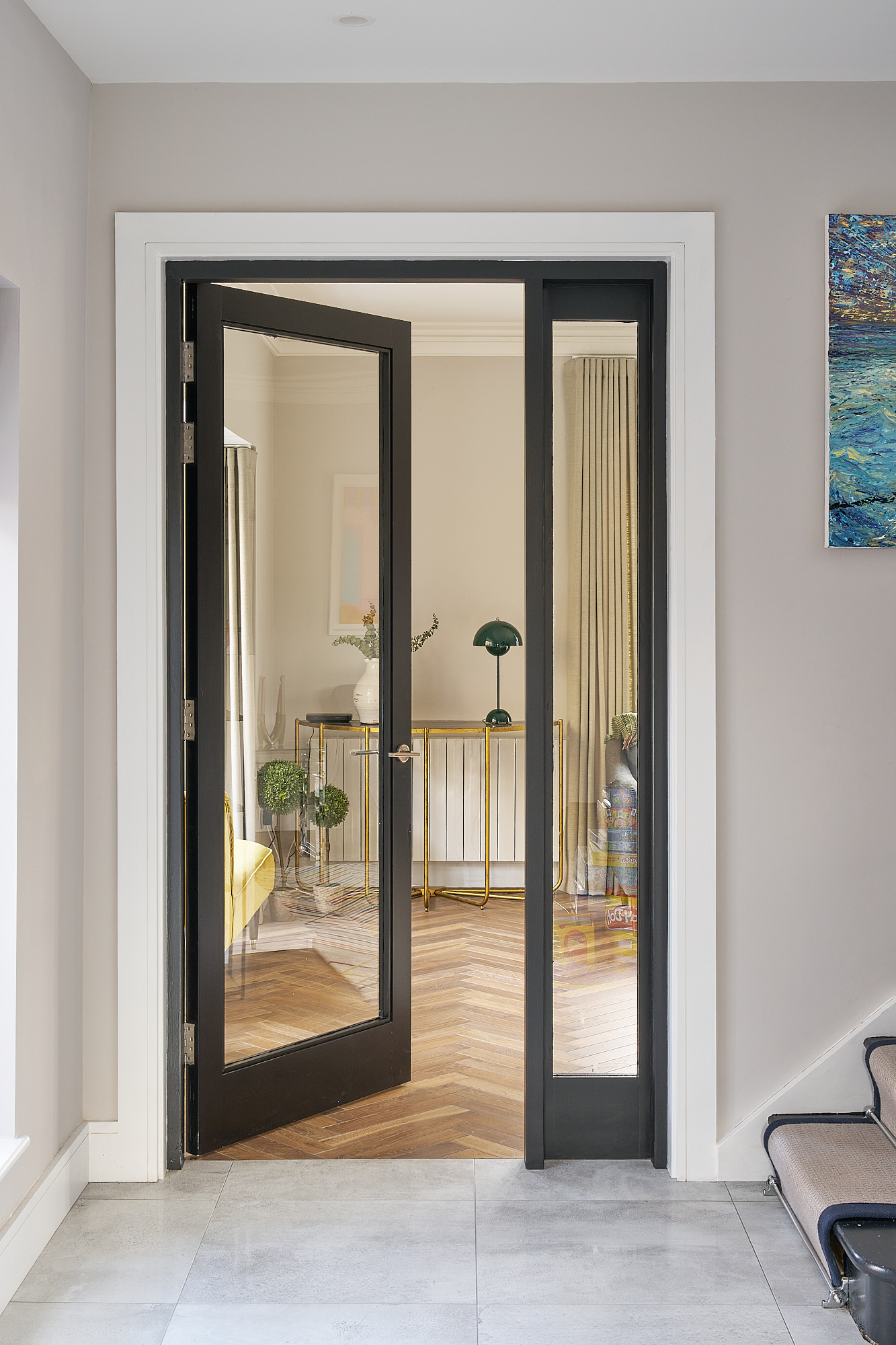 The entrance hallway, with mirrored black-framed doors and tiled flooring