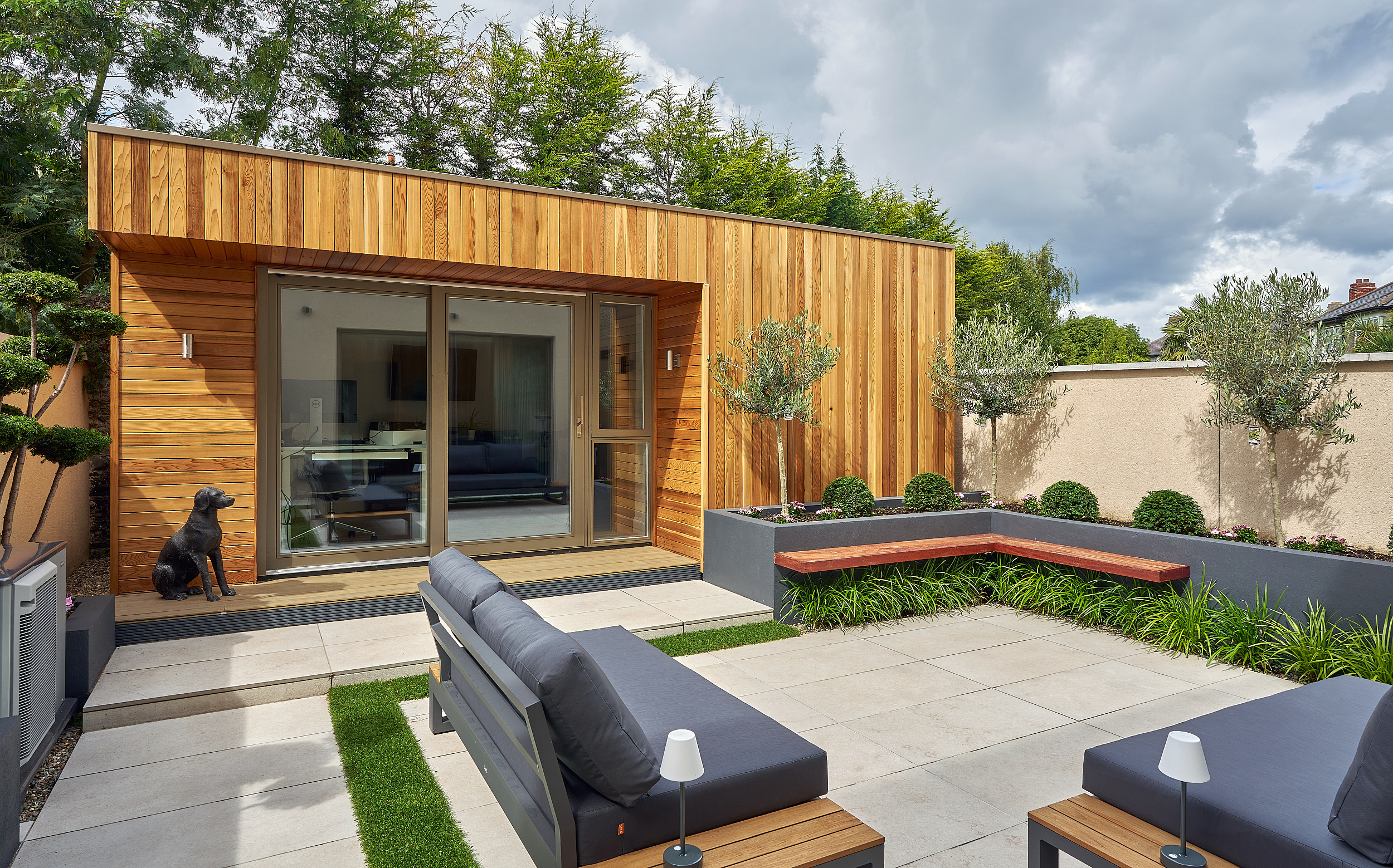 The studio with its sliding doors open onto the terrace, seen across the outdoor seating