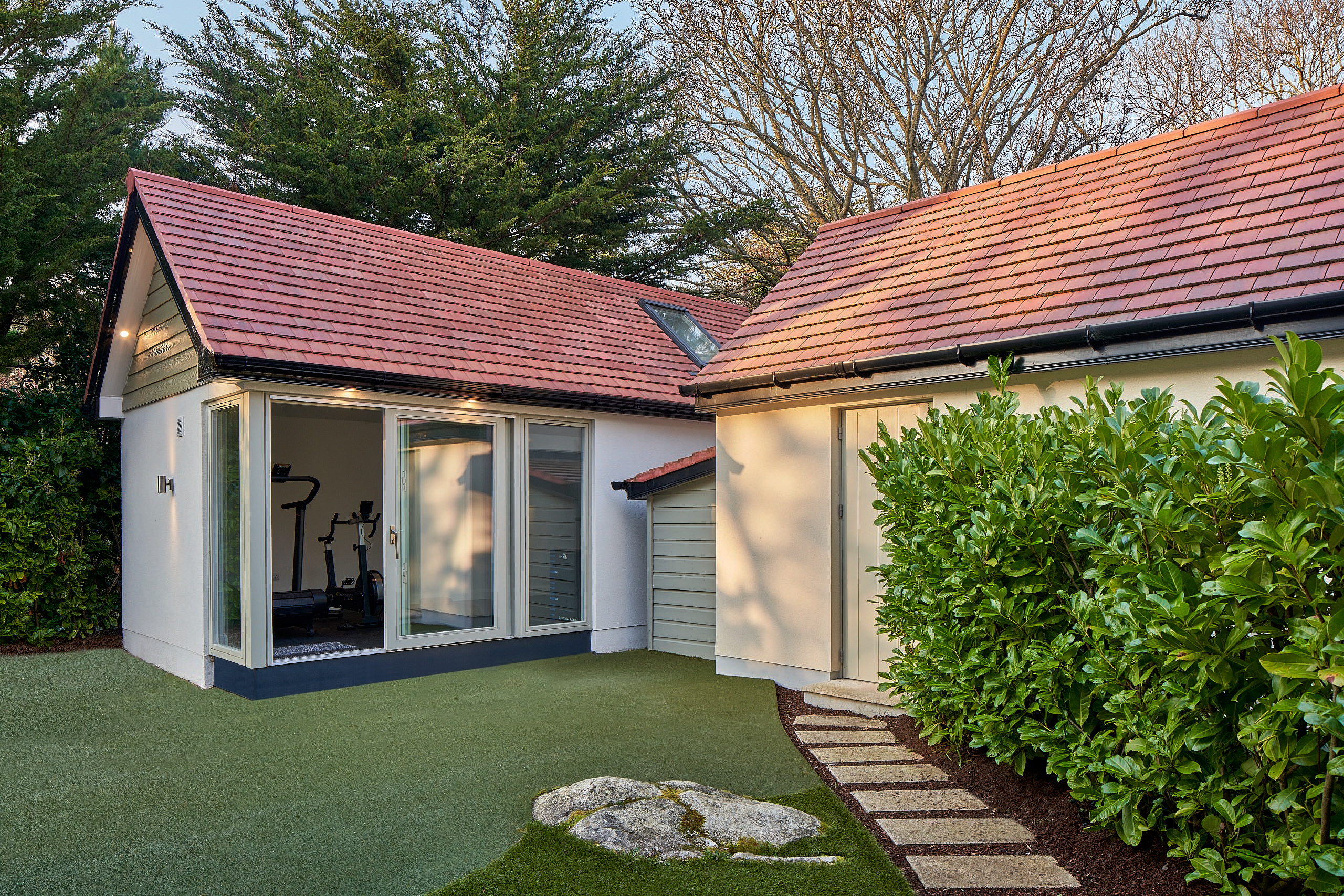 The studio and the adjoining house, stepping stones running through the planting