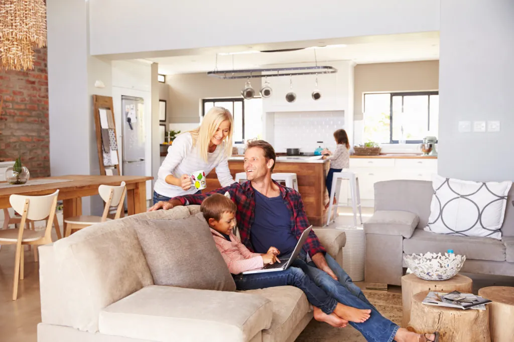 A family relaxing on a sofa in an open-plan living room and kitchen