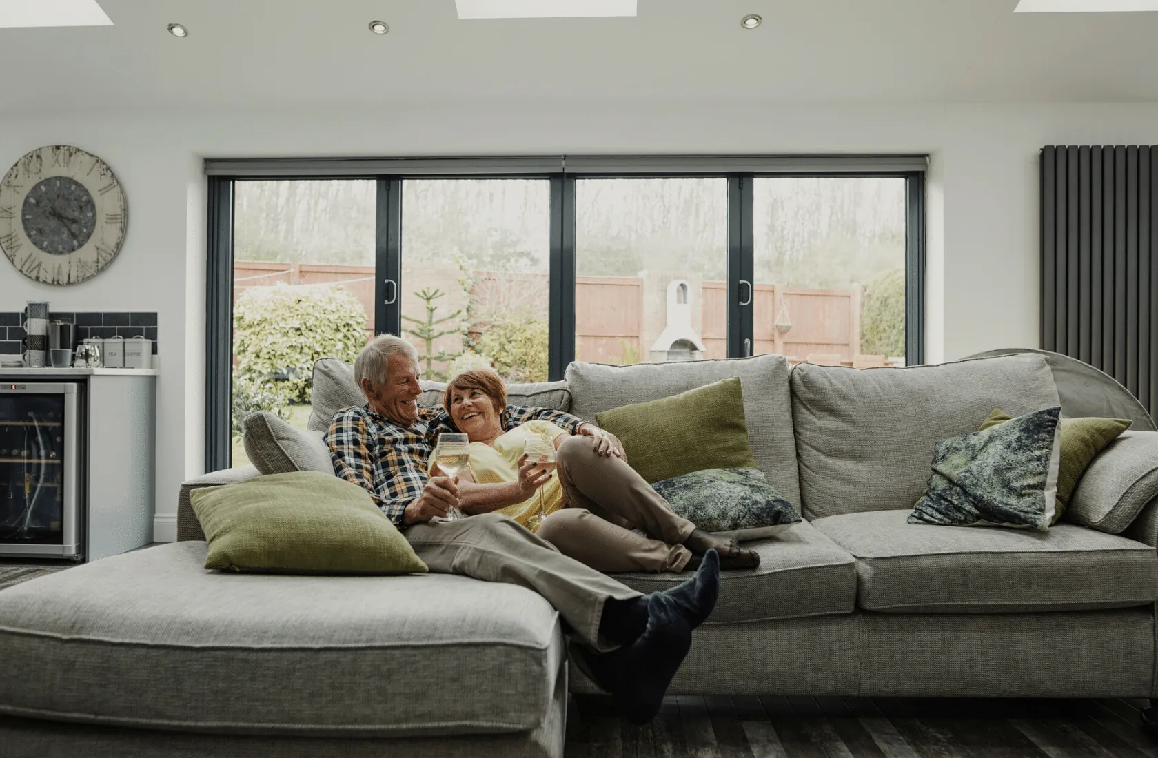 A couple relaxing on a sofa in front of sliding glass doors