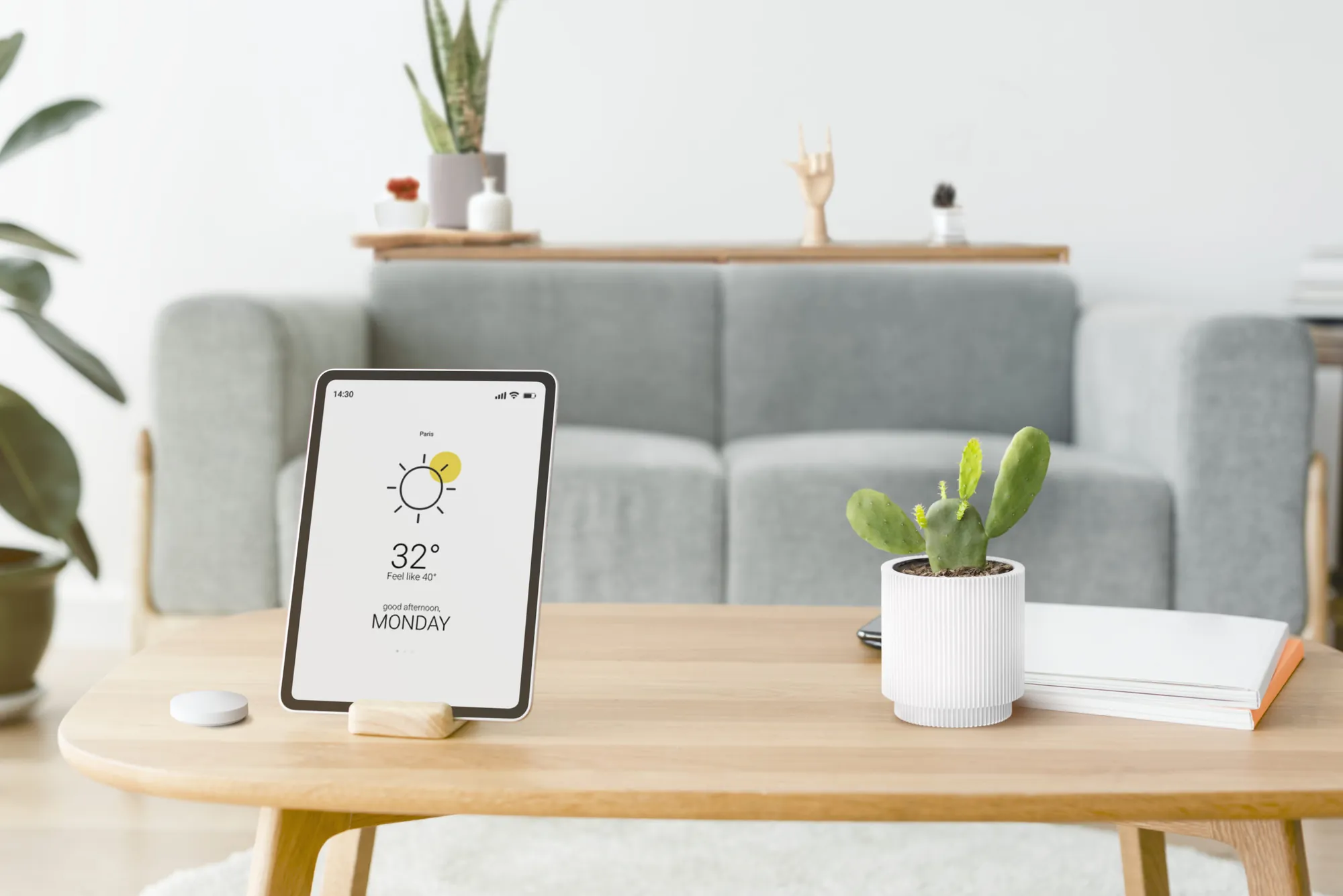 A tablet showing a weather display on a coffee table in a living room