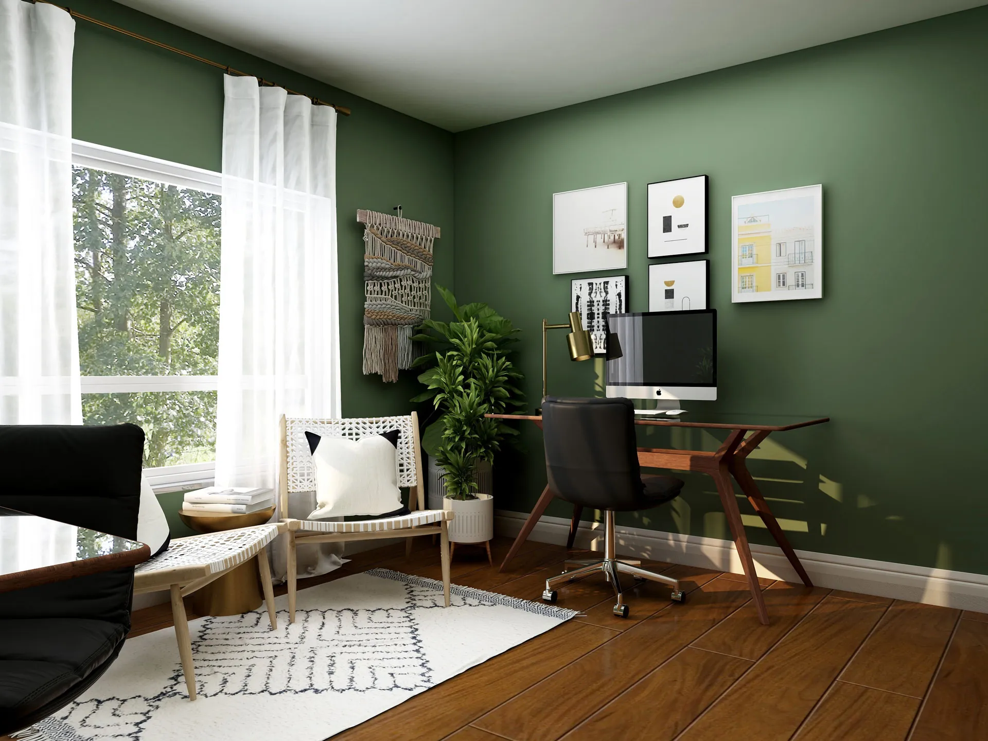 A home office with green walls, a desk and computer, framed prints and a large window