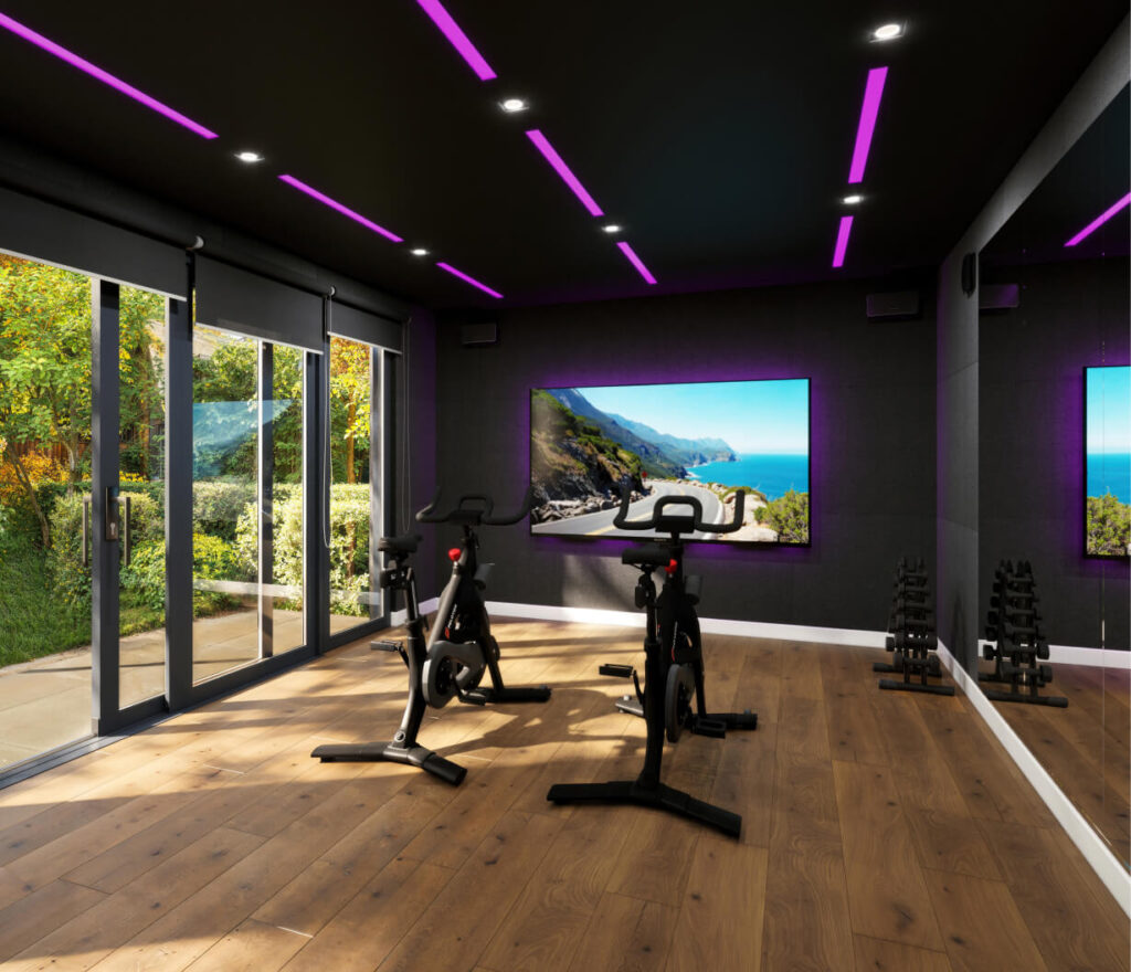 Interior of a luxury spin garden studio equipped with two peloton bikes, a large screen and projector, and a mirrored wall